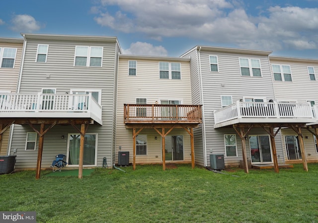 rear view of property with a lawn and central air condition unit