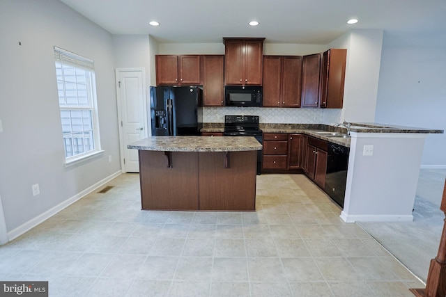 kitchen with a sink, black appliances, recessed lighting, decorative backsplash, and a kitchen island
