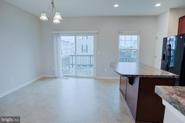 kitchen featuring a kitchen island, recessed lighting, black fridge with ice dispenser, a notable chandelier, and baseboards
