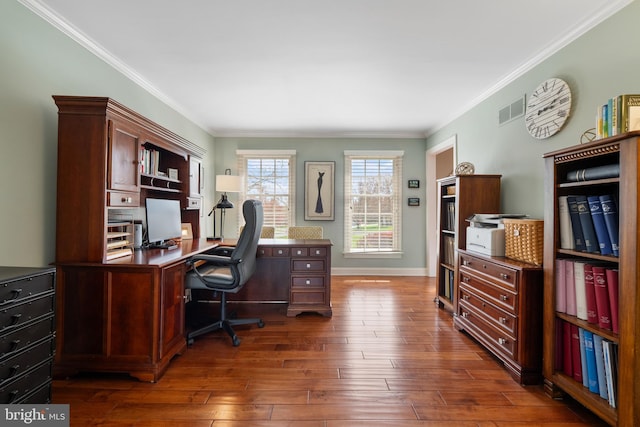 office space with dark wood-style flooring, baseboards, ornamental molding, and visible vents