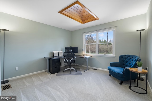 home office featuring visible vents, light colored carpet, baseboards, and a skylight