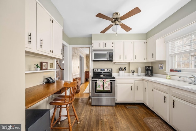 kitchen featuring dark wood-style flooring, ceiling fan, appliances with stainless steel finishes, white cabinetry, and a sink