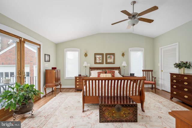 bedroom featuring baseboards, wood finished floors, and vaulted ceiling