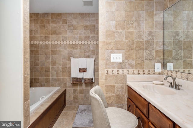bathroom featuring tile walls, visible vents, a bathing tub, tile patterned floors, and vanity