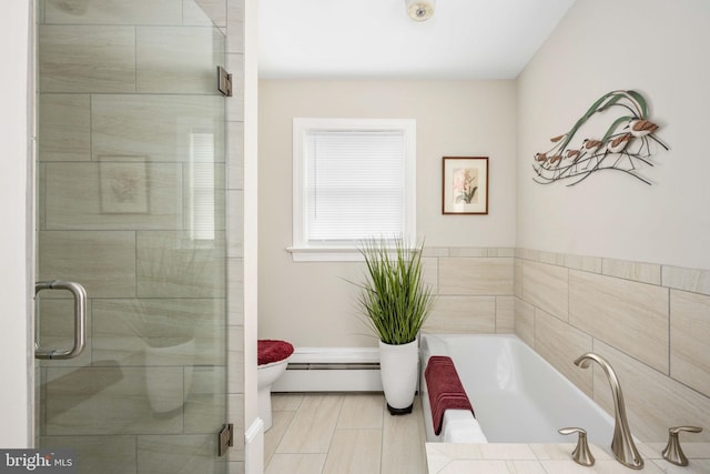 full bath featuring toilet, a shower stall, a garden tub, and baseboard heating