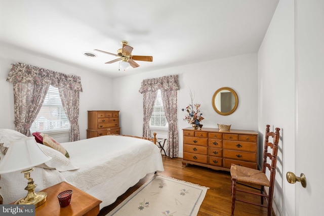 bedroom featuring ceiling fan, visible vents, and wood finished floors