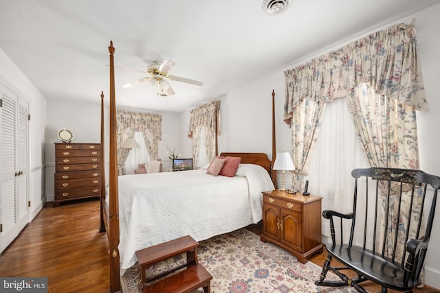 bedroom featuring visible vents, multiple windows, a ceiling fan, and wood finished floors