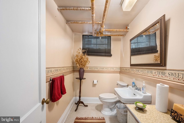 half bathroom with tile patterned flooring, a sink, and toilet