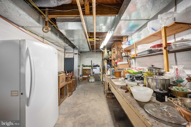 unfinished basement with freestanding refrigerator