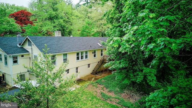 24 Montague Ave, Ewing, NJ 08628 - view of side of home featuring a shingled roof, a chimney, stairs, and a wooden deck