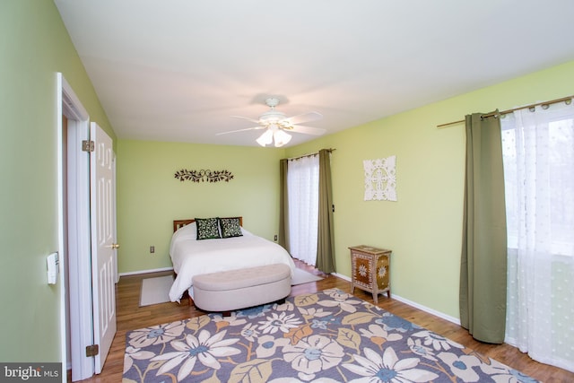 bedroom with baseboards, ceiling fan, and wood finished floors