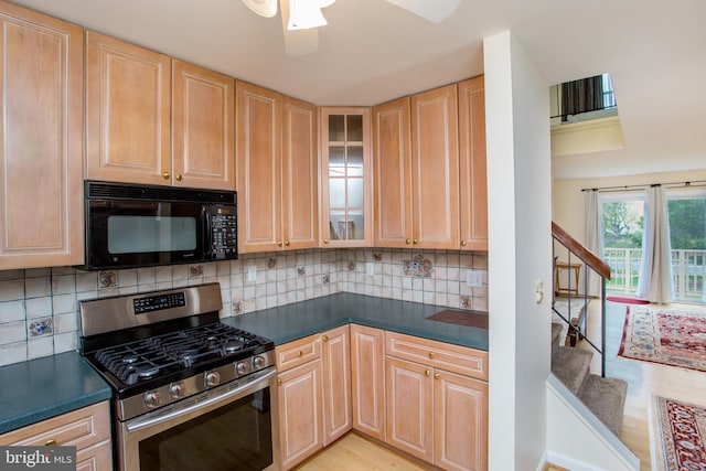 kitchen featuring light brown cabinetry, stainless steel gas range oven, and black microwave