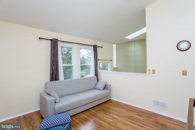 sitting room featuring a skylight, wood finished floors, baseboards, and visible vents