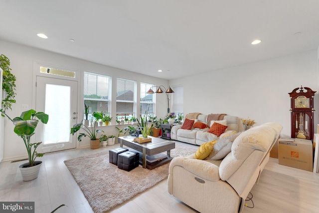 living room with light wood-type flooring and recessed lighting