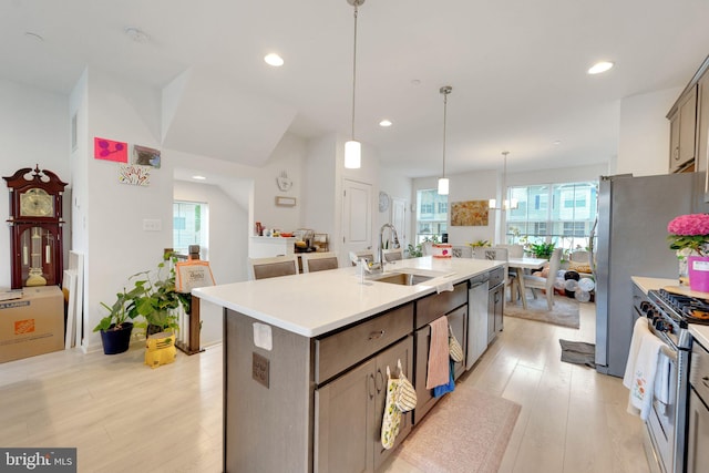 kitchen with a sink, light wood-style flooring, stainless steel appliances, plenty of natural light, and recessed lighting