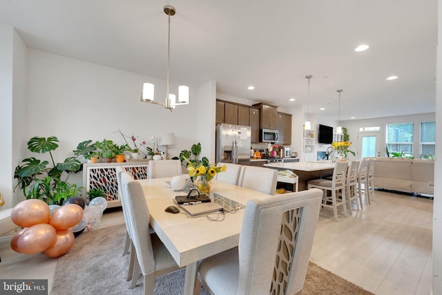 dining room featuring recessed lighting, light wood finished floors, and a chandelier
