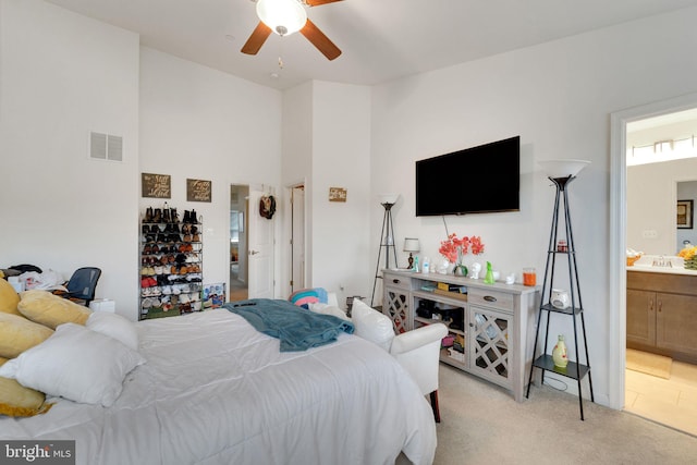 bedroom featuring light carpet, connected bathroom, and ceiling fan
