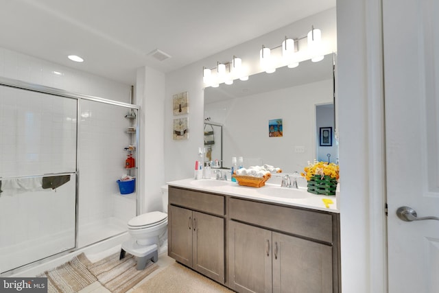 bathroom featuring a shower stall, double vanity, toilet, and recessed lighting