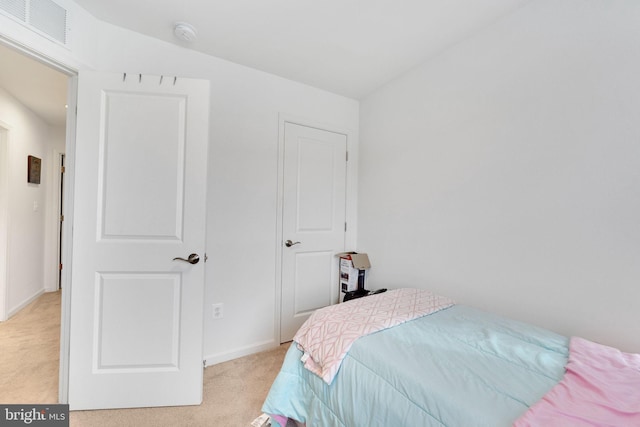 bedroom with light colored carpet and baseboards