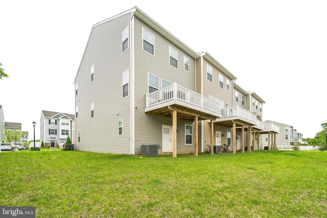 back of property featuring a lawn, central AC unit, and a deck