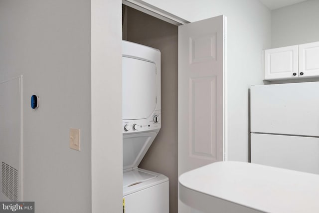 laundry area with laundry area and stacked washer / drying machine