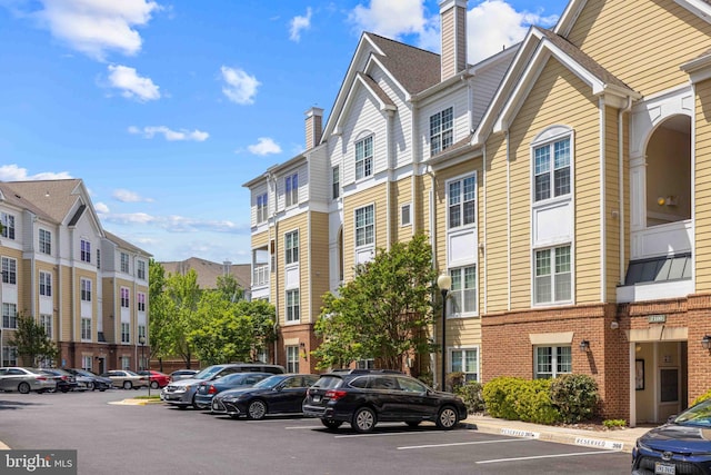 view of property featuring a residential view and uncovered parking