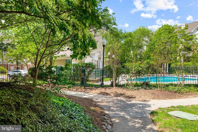 view of home's community featuring a swimming pool and fence