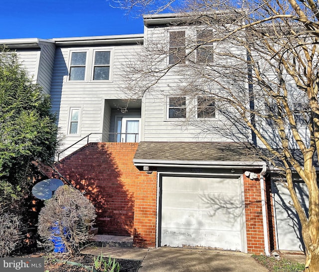 view of front facade featuring an attached garage, brick siding, and driveway