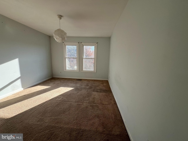 empty room featuring baseboards and carpet flooring
