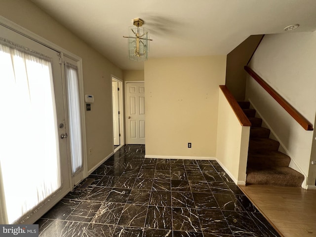 foyer entrance with marble finish floor, baseboards, and stairway