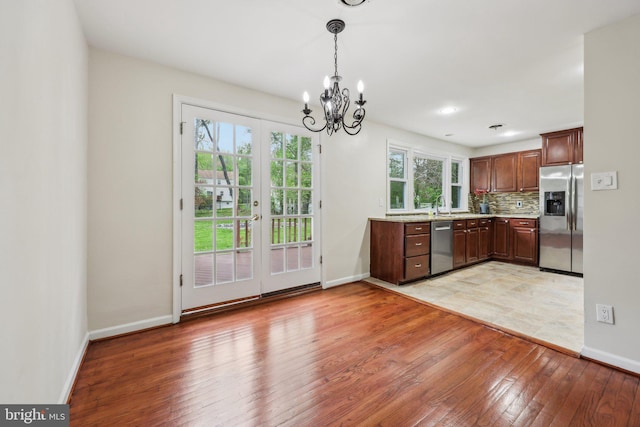 9532 Sherwood Dr, Upper Marlboro, MD 20772 - kitchen with light countertops, baseboards, light wood finished floors, an inviting chandelier, and stainless steel appliances
