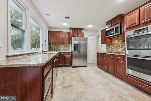 9532 Sherwood Dr, Upper Marlboro, MD 20772 - kitchen with a sink, light stone counters, backsplash, and stainless steel appliances