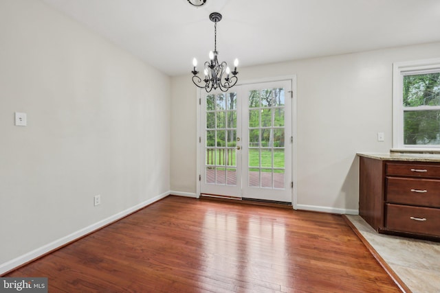 9532 Sherwood Dr, Upper Marlboro, MD 20772 - unfurnished dining area with baseboards, a notable chandelier, and light wood-type flooring
