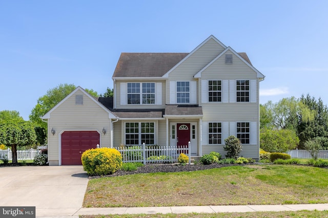 traditional home featuring fence, an attached garage, driveway, and a front lawn