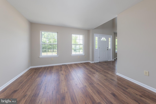 interior space featuring baseboards, dark wood-style flooring, and vaulted ceiling