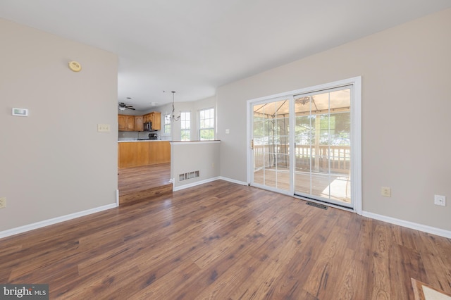 unfurnished living room with baseboards, dark wood finished floors, and visible vents