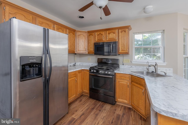 kitchen with ceiling fan, a sink, light countertops, dark wood finished floors, and black appliances