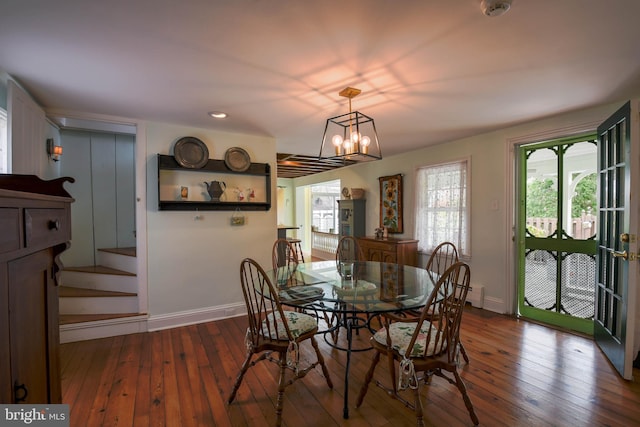 dining area with baseboard heating, baseboards, a notable chandelier, and hardwood / wood-style floors