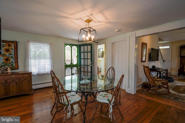 dining area featuring baseboard heating, a wealth of natural light, and hardwood / wood-style flooring
