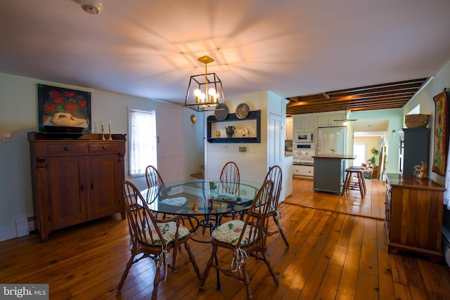 dining room with an inviting chandelier, hardwood / wood-style flooring, and baseboard heating