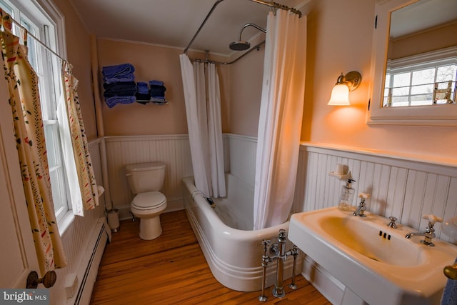 full bath with a baseboard heating unit, toilet, wainscoting, and wood finished floors