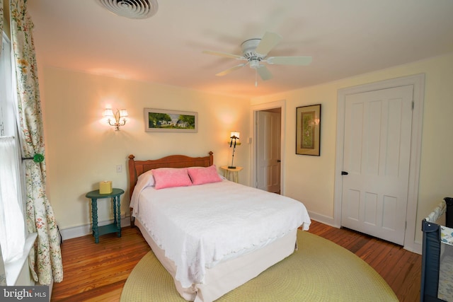 bedroom featuring ceiling fan, baseboards, wood finished floors, and visible vents