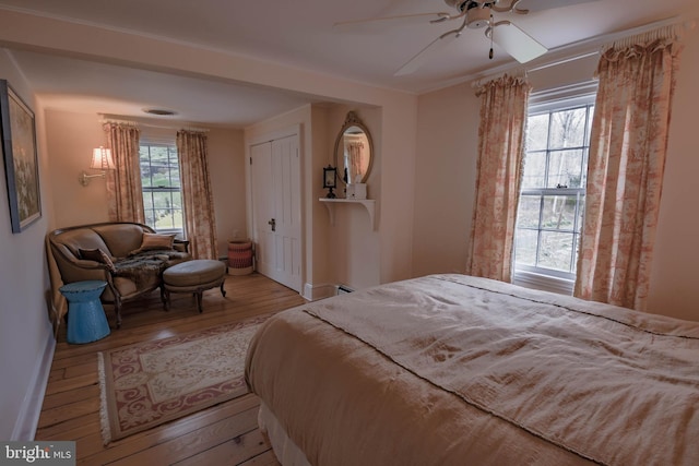 bedroom featuring ceiling fan, baseboards, and wood finished floors