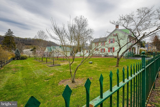 surrounding community with fence and a yard