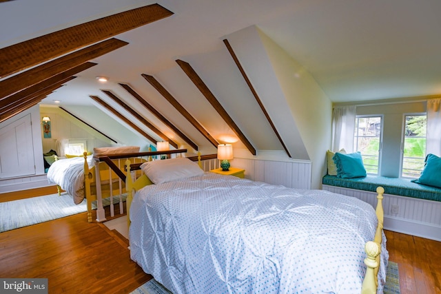 bedroom with lofted ceiling and wood finished floors