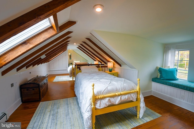 bedroom with a baseboard radiator, lofted ceiling, and hardwood / wood-style floors