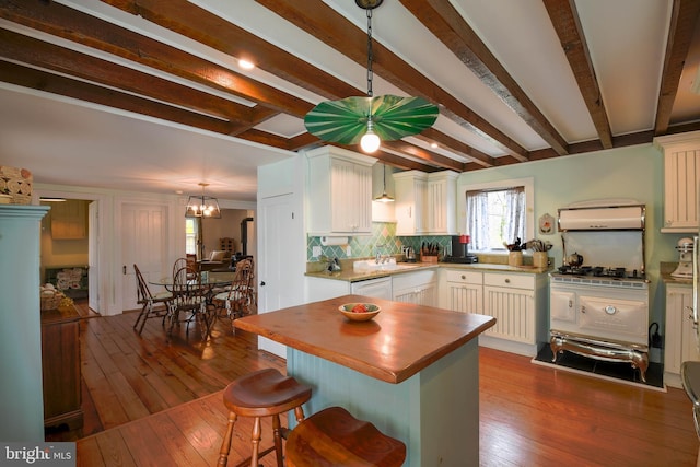 kitchen featuring a kitchen bar, dark wood finished floors, beam ceiling, and butcher block counters
