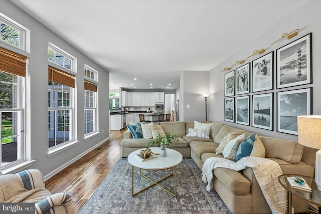 living area with recessed lighting, wood finished floors, and baseboards