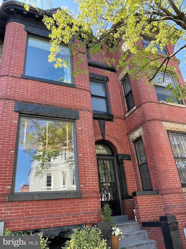 doorway to property with brick siding