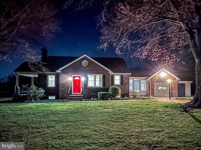view of front facade featuring entry steps, a yard, and brick siding